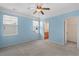 Bright blue bedroom with two windows, a ceiling fan, and a bathroom and closet in view at 908 Oglethorpe Dr., Conway, SC 29527