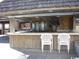 Outdoor bar area with a wood facade, white resin chairs, and a shingled roof at 9550 Shore Dr. # 1728, Myrtle Beach, SC 29572
