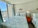 Bedroom featuring two beds with patterned quilts, ocean themed decorations, and access to a balcony at 9840 Queensway Blvd. # 1819, Myrtle Beach, SC 29572