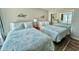 Bedroom featuring two beds with patterned quilts, ocean themed decorations, and access to a mirrored closet at 9840 Queensway Blvd. # 1819, Myrtle Beach, SC 29572