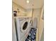 Hall laundry closet featuring a white washer and dryer, utility shelf, starfish themed rugs, and ironing board at 9840 Queensway Blvd. # 1819, Myrtle Beach, SC 29572