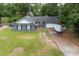 Charming single-story home with a brick facade and a long driveway, surrounded by lush greenery and mature trees at 106 Azalea Dr., Conway, SC 29526
