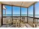 Screened porch with table and chairs, offering beautiful ocean views at 108 N Ocean Blvd. # 301, North Myrtle Beach, SC 29582