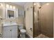An updated bathroom features a glass shower with a stone tile floor and a white vanity at 108 N Ocean Blvd. # 308, North Myrtle Beach, SC 29582