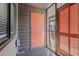 Entryway with an orange door and a screened door leading to the outside, complemented by gray wood siding at 108 N Ocean Blvd. # 308, North Myrtle Beach, SC 29582