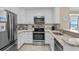 Updated kitchen featuring white cabinetry, granite countertops, and stainless steel appliances at 108 N Ocean Blvd. # 308, North Myrtle Beach, SC 29582