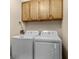 Laundry room with white washer and dryer and wooden cabinets for storage above at 108 N Ocean Blvd. # 308, North Myrtle Beach, SC 29582