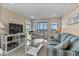 Bright living room with a plush sofa, chair, and ocean views from the screened-in porch at 108 N Ocean Blvd. # 308, North Myrtle Beach, SC 29582