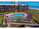 Aerial perspective of a community pool, hot tub, sun deck and lounge area with ocean view in the background at 108 N Ocean Blvd. # 308, North Myrtle Beach, SC 29582