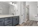 Bathroom featuring blue vanity, framed mirror, black hardware, and a tiled walk-in shower at 1127 Crooked Hook Rd., North Myrtle Beach, SC 29582