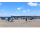 Scenic view of a pier on a sandy beach with umbrellas and beachgoers under a clear, sunny sky at 1127 Crooked Hook Rd., North Myrtle Beach, SC 29582
