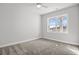 A serene bedroom with neutral carpeting, a ceiling fan, and a window providing ample light at 1127 Crooked Hook Rd., North Myrtle Beach, SC 29582