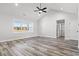 Bright living room with vaulted ceiling, ceiling fan, large window, and wood-look flooring at 1127 Crooked Hook Rd., North Myrtle Beach, SC 29582