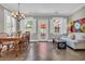 Sunlit dining room with hardwood floors, modern lighting, and a white sofa, creating a welcoming atmosphere at 1136 Doubloon Dr., North Myrtle Beach, SC 29582