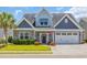 Charming two-story home featuring stone accents, gray siding, well-manicured lawn, and an attached two-car garage at 1136 Doubloon Dr., North Myrtle Beach, SC 29582