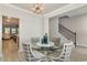 Cozy dining area with a glass table, staircase access, and an open view of the living room at 141 Ranch Haven Dr., Murrells Inlet, SC 29576