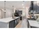 Bright, modern kitchen with large island, dark cabinets, stainless steel appliances, and light wood flooring at 141 Ranch Haven Dr., Murrells Inlet, SC 29576