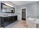 Bathroom with dual sink vanity, granite counters, and soaking tub with tile surround at 1800 Wood Stork Dr., Conway, SC 29526