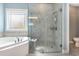 Bathroom featuring a tiled walk-in shower, soaking tub and a frosted window at 1800 Wood Stork Dr., Conway, SC 29526