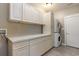 Well-organized laundry room with white cabinets, countertop space, and stacked washer/dryer at 1800 Wood Stork Dr., Conway, SC 29526