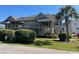 Charming condo with palm trees, well-kept landscaping, and inviting walkways to upper-level entrances at 1870 Auburn Ln. # 21 E, Surfside Beach, SC 29575