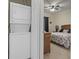 Inviting bedroom featuring a wicker headboard and a view of the in-unit washer and dryer at 2090 Cross Gate Blvd. # 205, Surfside Beach, SC 29575