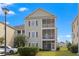 Charming three-story condo featuring screened porches and manicured landscaping against a clear blue sky at 2090 Cross Gate Blvd. # 205, Surfside Beach, SC 29575
