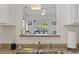 Sink view into a sunlit living room, offering an open and inviting space for entertaining and relaxation at 2090 Cross Gate Blvd. # 205, Surfside Beach, SC 29575