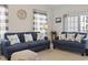 Bright living room features blue sofas, beach-themed decor, and plenty of natural light at 2090 Cross Gate Blvd. # 205, Surfside Beach, SC 29575