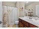 Well-lit bathroom featuring a vanity sink with dark wood cabinets and a shower/tub with wheat-themed curtain at 232 Je Edward Dr. # 21, Myrtle Beach, SC 29588