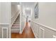 Spacious hallway featuring hardwood floors, crown molding, staircase, and stylish wall decor throughout at 232 Je Edward Dr. # 21, Myrtle Beach, SC 29588