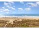 Sweeping view of the beach showing sand dunes, beachgoers, and the beautiful Atlantic ocean at 2507 S Ocean Blvd. # 403, North Myrtle Beach, SC 29582