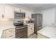 Modern kitchen with stainless steel appliances, white cabinets, and marble countertops at 2507 S Ocean Blvd. # 403, North Myrtle Beach, SC 29582