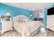 Inviting main bedroom with blue walls, a king bed, balcony access and dresser with a TV at 2507 S Ocean Blvd. # 403, North Myrtle Beach, SC 29582