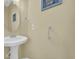 Bright half bathroom with pedestal sink, neutral wall color, and decorative wall art at 260 Connemara Dr. # E, Myrtle Beach, SC 29579