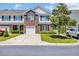 Charming townhome exterior featuring brick accents, black shutters, and well-maintained landscaping at 260 Connemara Dr. # E, Myrtle Beach, SC 29579