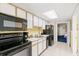 Functional kitchen equipped with modern black appliances, white cabinetry, and tiled floors at 2701 S Ocean Blvd. # 1603, North Myrtle Beach, SC 29582