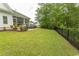 Expansive backyard featuring a lush lawn, black fence, and patio with a grill, perfect for outdoor entertaining at 2928 Moss Bridge Ln., Myrtle Beach, SC 29579