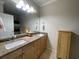 Bathroom featuring double sinks, wood cabinets and a large mirror at 307 Black Oak Ln. # 102, Murrells Inlet, SC 29576