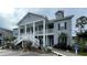 Attractive condo building with covered porches, white railings and stairs, gray siding, and manicured landscaping at 307 Black Oak Ln. # 102, Murrells Inlet, SC 29576