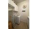 Well-lit laundry room featuring white cabinets, shelving, and modern washer and dryer units at 307 Black Oak Ln. # 102, Murrells Inlet, SC 29576