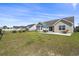 Lush backyard with green lawn, black fence, patio area, and a table with umbrella at 313 Palladium Dr., Surfside Beach, SC 29575