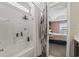 Bright bathroom featuring a shower-tub combo with built-in shelving and access to the main bedroom at 313 Palladium Dr., Surfside Beach, SC 29575