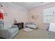 Cozy bedroom with soft pink walls, a floral mural, and a comfy armchair at 313 Palladium Dr., Surfside Beach, SC 29575