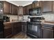 Modern kitchen with dark cabinetry, stainless steel appliances, and stylish backsplash at 313 Palladium Dr., Surfside Beach, SC 29575