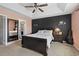 Cozy main bedroom featuring tray ceilings, ceiling fan, dark accent wall, and ensuite bath at 313 Palladium Dr., Surfside Beach, SC 29575