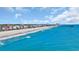 Breathtaking aerial view of the beach with blue water, a fishing pier, and colorful beachfront homes at 324 S Waccamaw Dr., Garden City Beach, SC 29576