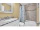 Well-lit bathroom featuring a granite countertop, decorative mirror and tiled shower and tub combination at 324 S Waccamaw Dr., Garden City Beach, SC 29576