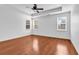 Light-filled bedroom with hardwood flooring, fan, and three large windows at 3315 Saddlewood Circle, Myrtle Beach, SC 29579
