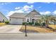 Charming single-story home features a manicured lawn, palm tree, and neutral siding at 3315 Saddlewood Circle, Myrtle Beach, SC 29579